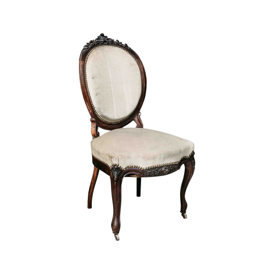 Lovely antique French salon chair in a dusty cream upholstery and on small front castor wheels