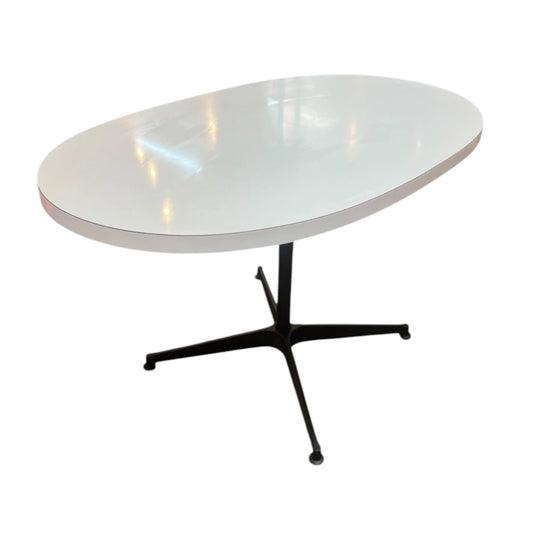 White oval dining table with black steel pedestal base