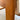 Close-up of a wooden leg with a visible scratch, part of the Tessa Monaco Armchair – Sage Green Like New (Revive). The background shows beige fabric and a blurred floor, highlighting this elegant armchair’s unique leather accents.