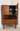 Danish mid-century teak corner cabinet with doors open revealing a mirrored cocktail bar interior, open shelf and three storage drawers