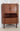 Danish mid-century teak corner cabinet with doors open revealing a mirrored cocktail bar interior, open shelf and three storage drawers