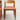 The Fully Restored THB 'Milan' Dining Chairs Set of 4 (Rediscover) includes wooden chairs with curved backrests, tapered legs, and rust-colored cushioned seats. Two similar chairs are partially visible beside it against a plain light wall.