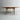 The Fully Restored Parker 140 Square Extension Table (Rediscover) features angled legs and a central drawer, set against a light gray wall and concrete floor to highlight its clean, minimalist mid-century modern design.