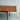 A close-up of the Fully Restored Parker 140 Square Extension Table (Rediscover) with a right drop-leaf extension, tapered legs, and a polished finish, set on a concrete floor against a plain gray wall for mid-century modern style.
