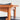 Close-up of the Fully Restored Parker 140 Square Extension Table (Rediscover) with rounded legs and a matching chair with black seat and backrest, set against a light textured background.