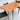 A Fully Restored Parker 140 Square Extension Table (Rediscover) with an extension leaf pulled out is paired with three black leather chairs on a light gray concrete floor against a plain wall.