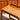 A close-up of the Mid-Century Noblett Drinks Trolley with removable tray and original castors, showcasing its clean lines and smooth light wood grain finish in a sunlit room, positioned near matching Noblett furniture.