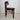 Side profile of a Danish mid‑century teak chair by Peter Hvidt, with curved back rail and square‑section legs