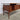Angled rear‑side view of 1960s Peter Løvig Nielsen teak desk showing teak panel back, tapered legs and sculptural Danish modern silhouette