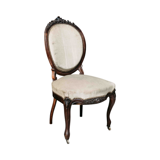 Lovely antique French salon chair in a dusty cream upholstery and on small front castor wheels