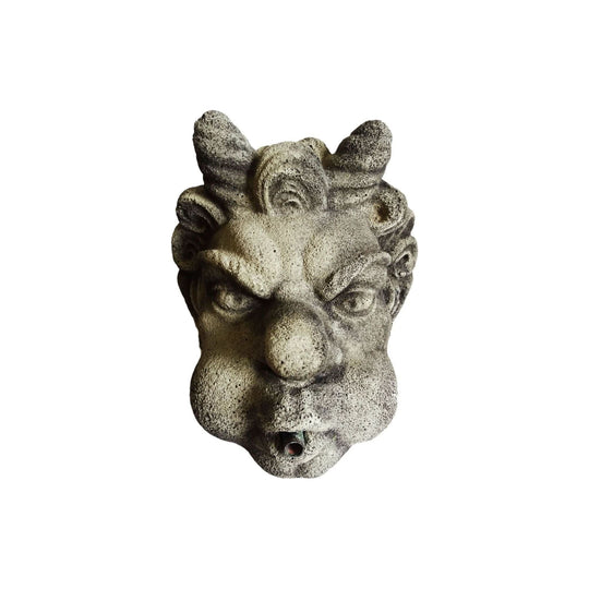 A cast stone devil fountain head with fitted copper spout
