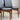 Two restored Parker 118 Slab Back Chairs with black leather seats and backs sit side by side on concrete, against a light gray wall. Shown here: Pre-Order Professional Restoration Parker 118 Chair Set of 4 (25% non-refundable deposit).