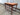 Three-quarter view of the mid-century side table with veneered top and tapered teak legs.