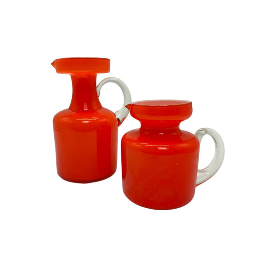 Pair of orange art glass jugs.